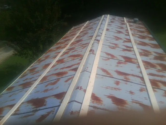 Rusted metal roof panels with new wood purlins before replacement — Storm Damage Roof Repair in East Earl by Roofing Brothers