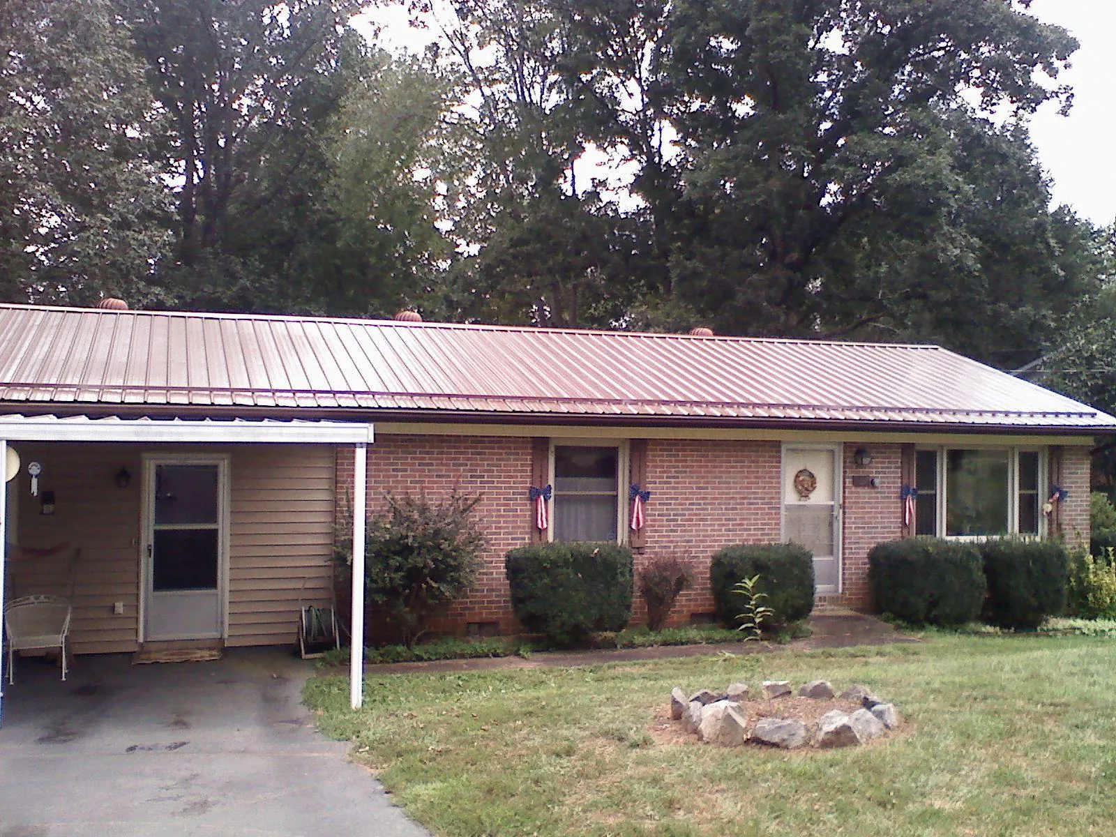 Bronze metal roof and carport on a brick ranch home — Roof Repair work by our crew in East Earl